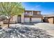 Charming two-story home with a three-car garage and paved driveway, shadowed by a tree at 7317 W Southgate Ave, Phoenix, AZ 85043