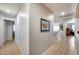 Neutral hallway featuring wood-look flooring, doorways to various rooms, and staircase in the background at 7317 W Southgate Ave, Phoenix, AZ 85043