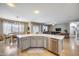 Kitchen island with a sink, dishwasher, and stylish cabinetry opens to the dining and living areas at 7317 W Southgate Ave, Phoenix, AZ 85043