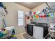 Well-organized laundry room equipped with washer, dryer, shelving and window for natural light at 7317 W Southgate Ave, Phoenix, AZ 85043