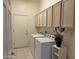 Functional laundry room featuring a washer, dryer, overhead cabinets, and tile floor at 7361 E Rugged Ironwood Rd, Gold Canyon, AZ 85118