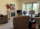 Cozy living room with a fireplace, neutral carpet and sliding door access to the patio at 7361 E Rugged Ironwood Rd, Gold Canyon, AZ 85118