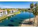 Scenic aerial view of lakeside condos with palm trees and a fountain under a clear blue sky at 7401 W Arrowhead Clubhouse Dr # 2045, Glendale, AZ 85308