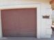 Attached two car garage with a neutral painted door and decorative address tile on the exterior stucco wall at 8371 W Santa Cruz Blvd, Arizona City, AZ 85123