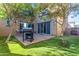 Grassy backyard featuring a grill, outdoor seating, and sliding glass doors to the interior at 857 S Osborn Ln, Gilbert, AZ 85296