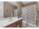 Standard bathroom featuring a single sink with brown cabinets and a shower with a patterned curtain at 857 S Osborn Ln, Gilbert, AZ 85296