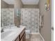 Standard bathroom featuring a single sink with brown cabinets and a shower with a patterned curtain at 857 S Osborn Ln, Gilbert, AZ 85296