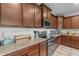 Well-lit kitchen features granite counters, stainless steel appliances, and brown cabinets at 857 S Osborn Ln, Gilbert, AZ 85296