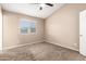 Neutral bedroom with plush carpet, ceiling fan, and a bright window at 8738 W Mountain View Rd, Peoria, AZ 85345