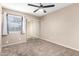 Bright bedroom featuring plush carpet, ceiling fan, and mirrored closet doors at 8738 W Mountain View Rd, Peoria, AZ 85345