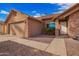 Welcoming home featuring a brick facade, two-car garage and low maintenance desert landscaping at 8738 W Mountain View Rd, Peoria, AZ 85345