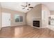 Spacious living room with a fireplace, wood floors, and ample natural light through large windows at 8738 W Mountain View Rd, Peoria, AZ 85345