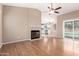 Bright living room featuring wood floors, fireplace, and a view to the kitchen and backyard pool at 8738 W Mountain View Rd, Peoria, AZ 85345