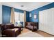 Blue-walled Bedroom featuring a crib, accent chair, and natural light at 1010 E Vernoa St, San Tan Valley, AZ 85140