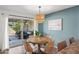 Cozy dining area with a round wooden table, stylish chairs, and a sliding glass door to the patio at 11604 S Ki Rd, Phoenix, AZ 85044