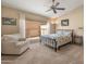 Relaxing main bedroom with a bed, comfy chair, a large window, neutral carpet and soothing wall colors, plus a ceiling fan at 13828 S 42Nd St, Phoenix, AZ 85044