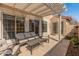 Relaxing covered patio with comfortable seating, a metal coffee table, and an overhead pergola offering shade and style at 13828 S 42Nd St, Phoenix, AZ 85044