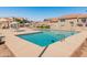 Community pool area with clear blue water, lounge chairs, and umbrellas for a refreshing outdoor experience at 13828 S 42Nd St, Phoenix, AZ 85044