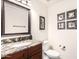 Powder room featuring a granite vanity top, framed mirror, and decorative wall art at 14244 N 14Th Pl, Phoenix, AZ 85022