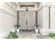 Elegant double doors are flanked by plants creating a grand entrance to this desert home at 14244 N 14Th Pl, Phoenix, AZ 85022