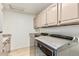 Well-lit laundry room with a utility sink, modern washer and dryer, and ample cabinet space at 14244 N 14Th Pl, Phoenix, AZ 85022