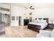 Bright main bedroom featuring a ceiling fan, wood-look floors, and an attached bathroom at 14244 N 14Th Pl, Phoenix, AZ 85022