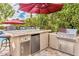 Covered outdoor kitchen with a built-in BBQ grill, refrigerator, and counter space, perfect for entertaining guests at 14244 N 14Th Pl, Phoenix, AZ 85022