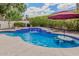 Inviting backyard pool with water features, blue tile trim, and a relaxing lounge area under a red umbrella at 14244 N 14Th Pl, Phoenix, AZ 85022