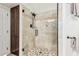 Tiled shower with a glass door, mosaic tile floor, and built-in storage at 14244 N 14Th Pl, Phoenix, AZ 85022