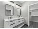 Elegant bathroom showcasing double sinks, modern lighting, and a walk-in closet at 15868 N 18Th N Pl, Phoenix, AZ 85022