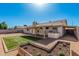 Backyard oasis featuring manicured lawn, covered patio area, a grill, and a garden bed at 1614 W Beaubien Dr, Phoenix, AZ 85027