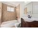 Well-lit bathroom featuring a shower-over-tub combination and neutral-toned tile surround at 1614 W Beaubien Dr, Phoenix, AZ 85027