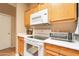 A well-maintained kitchen with wooden cabinetry and modern white appliances at 1951 N 64Th St # 26, Mesa, AZ 85205