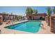 Community pool and hot tub with lounge chairs, tables, and covered seating area at 1951 N 64Th St # 26, Mesa, AZ 85205