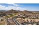 An aerial view of houses near a golf course nestled in a desert mountain community at 202 W Twin Peaks Pkwy, San Tan Valley, AZ 85143