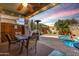 Cozy covered patio with dining area, outdoor kitchen, and a sparkling pool, perfect for relaxing and entertaining at 202 W Twin Peaks Pkwy, San Tan Valley, AZ 85143