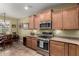 Kitchen featuring stainless steel appliances, wooden cabinets, and tile flooring at 202 W Twin Peaks Pkwy, San Tan Valley, AZ 85143