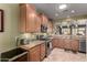 Bright kitchen featuring wooden cabinetry, granite countertops, and modern stainless steel appliances at 202 W Twin Peaks Pkwy, San Tan Valley, AZ 85143