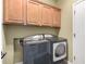 The laundry room features wood cabinets above the washer and dryer at 202 W Twin Peaks Pkwy, San Tan Valley, AZ 85143