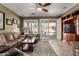 Cozy living room featuring tile flooring, plantation shutters, and sliding door access to the pool area at 202 W Twin Peaks Pkwy, San Tan Valley, AZ 85143