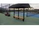 View of a well-maintained tennis court with shelter and benches for resting during play at 202 W Twin Peaks Pkwy, San Tan Valley, AZ 85143