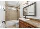 Bathroom features a tile shower/tub combo with a framed mirror above a wood vanity at 2110 E Laguna Dr, Tempe, AZ 85282