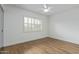 Bright bedroom with neutral walls, wood-look floors, ceiling fan and a shuttered window at 2110 E Laguna Dr, Tempe, AZ 85282