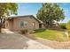 Charming single-story home with a well-maintained lawn, mature shade tree, and a paved driveway at 2110 E Laguna Dr, Tempe, AZ 85282