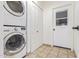 Convenient laundry room with a stacked washer and dryer, tile flooring, and ample storage space at 2110 E Laguna Dr, Tempe, AZ 85282