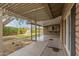 View of the covered patio area with concrete flooring, a serving window, and well-maintained green grass at 2110 E Laguna Dr, Tempe, AZ 85282