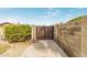 Gated side yard with a concrete path, brick wall, and lush greenery, offering privacy and curb appeal at 2110 E Laguna Dr, Tempe, AZ 85282