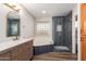 Bathroom featuring wood look floor, updated vanity and mirror, with soaking tub and glass enclosed shower stall at 2149 S Olivewood --, Mesa, AZ 85209