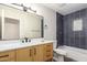 A modern bathroom featuring a wooden vanity, large mirror, and blue tiled shower for a spa-like experience at 2149 S Olivewood --, Mesa, AZ 85209