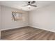 Bright bedroom features wood-look flooring, a ceiling fan, and natural light from a window, enhancing the room's appeal at 2149 S Olivewood --, Mesa, AZ 85209